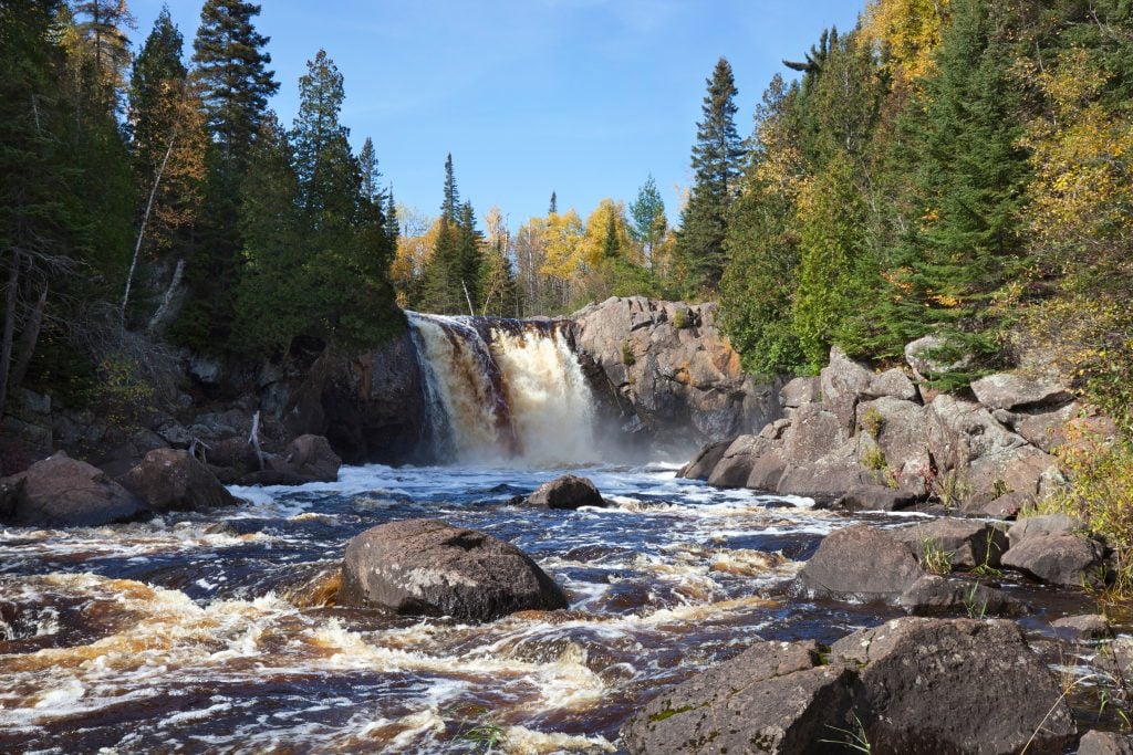 large waterfall surrounded by early fall foliage at minnesota north shore