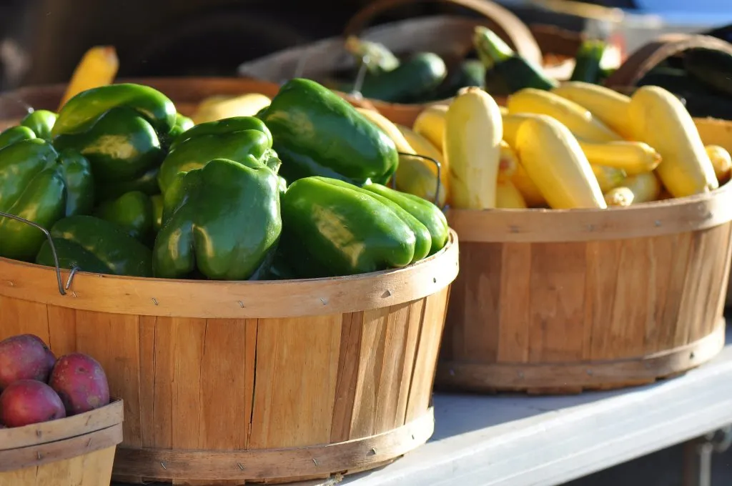 stacks of vegetables for sale in wooden baskets at farmers market nc