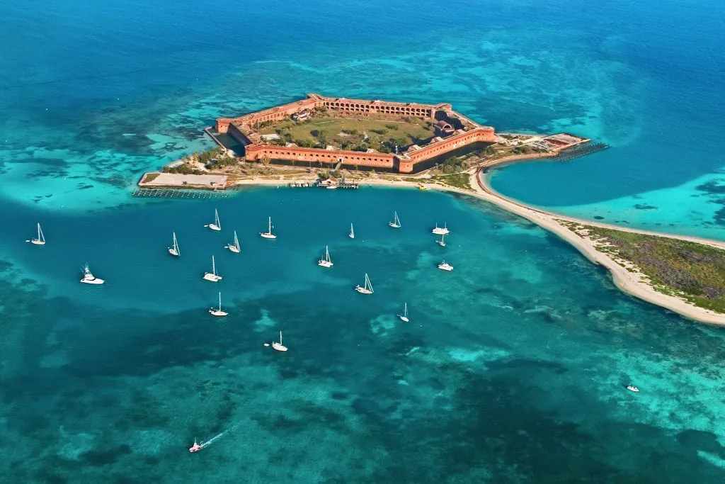 aerial view of dry tortugas national park with boats parked in the water around the island