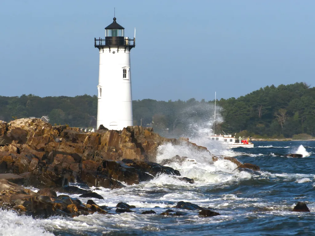 lighthouse in portsmouth new hampshire with waves crashing against rocks