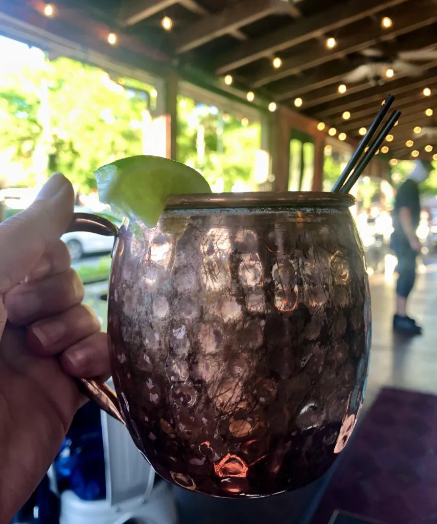 hand holding up a mule at glorias, one of the best outdoor dining restaurants moab utah