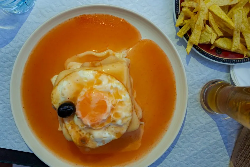 francesinha in porto portugal as seen from above topped with an egg, memorable thing to eat during an itinerary porto portugal