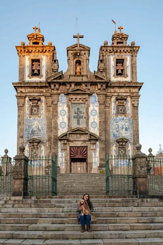 kate storm and ranger storm sitting on steps in front of igrejo de santo ildefonso during a itinerary for porto portugal