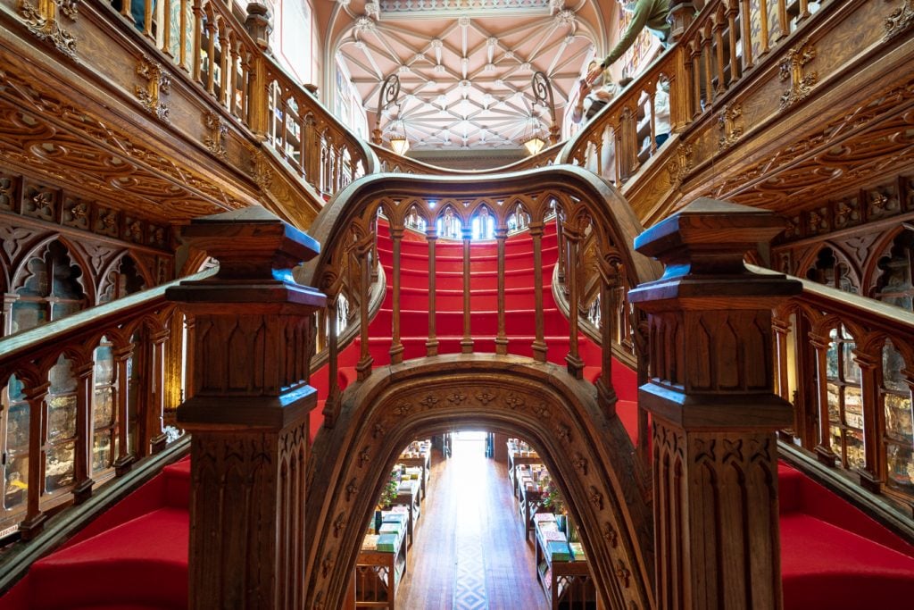 close up of livraria lello red staircase with banisters in the foreground