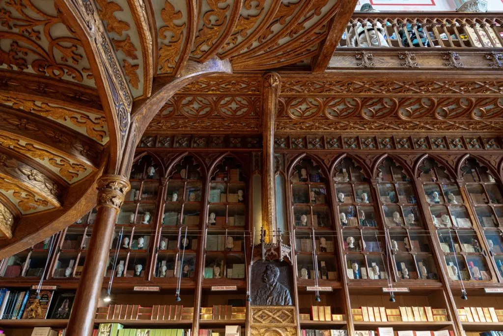 view of books on shelves looking up under staircase famous bookstore portugal