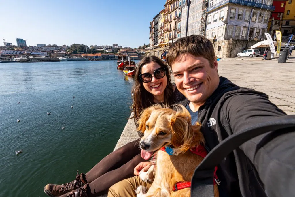 kate storm jeremy storm and ranger storm sitting on the edge of the duoro river porto portugal