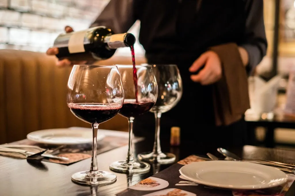 waiter pouring 3 glasses of red wine at a restaurant atlanta in 3 day weekend