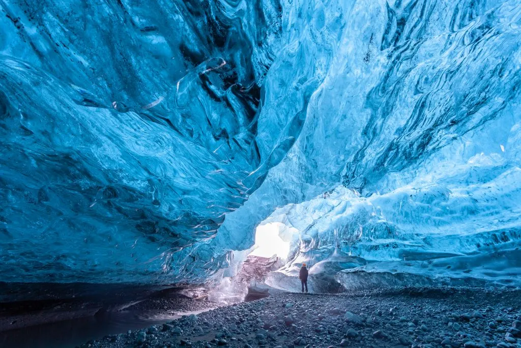 person standing inside an ice cave, bucket list iceland travel experience