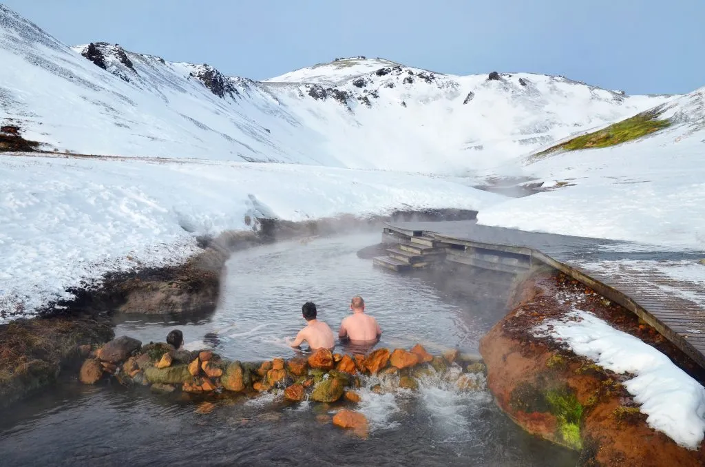 two people soaking in Reykjadalur Thermal River in winter in iceland things to do