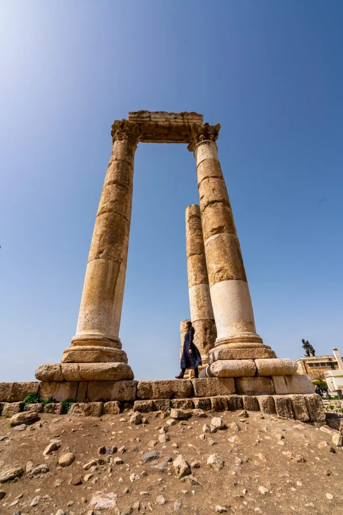 kate storm walking underneath columns at amman citadel during a week in jordan itinerary