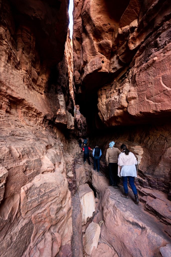 people hiking wadi rum slot canyon