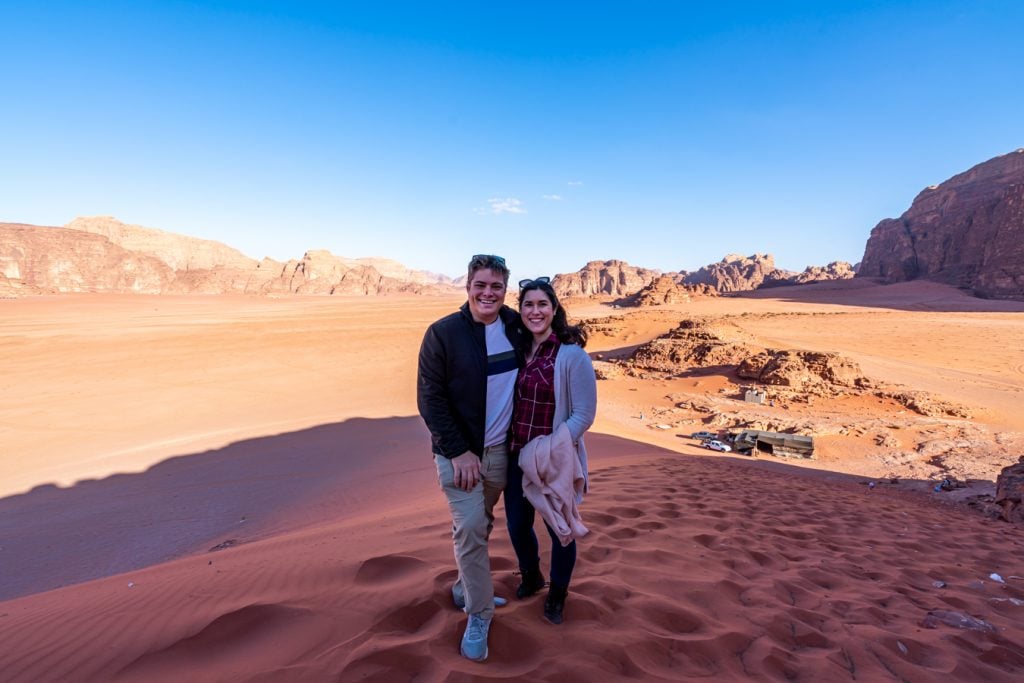 kate storm and jeremy storm standing on a sand dune when camping wadi rum jordan