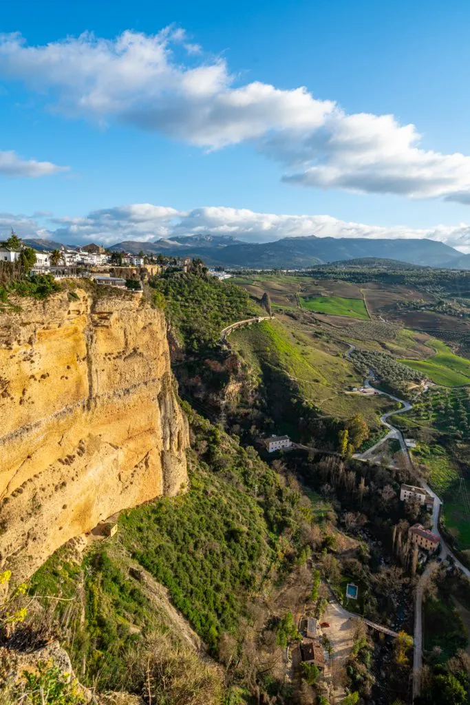view of cliff of ronda spain with countryside in the background, a fun addition to a 2 weeks in spain itinerary