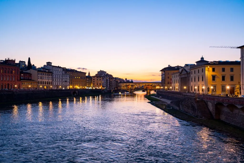 view of sunset over the ponte vecchio from a distance during evening in florence italy