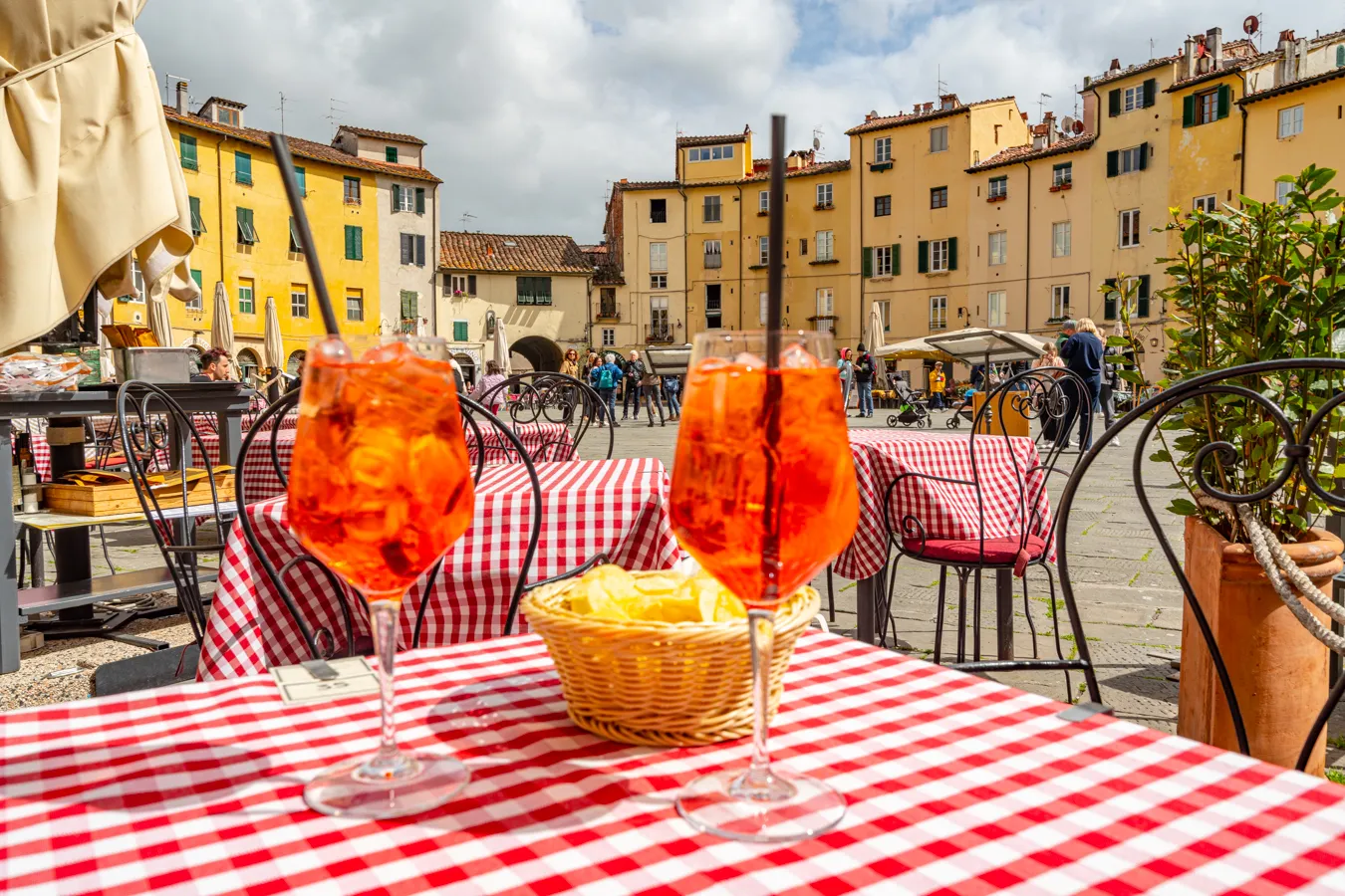 two aperol spritzes on a table in piazza dell'anfiteatro, one of the best things to do in lucca italy