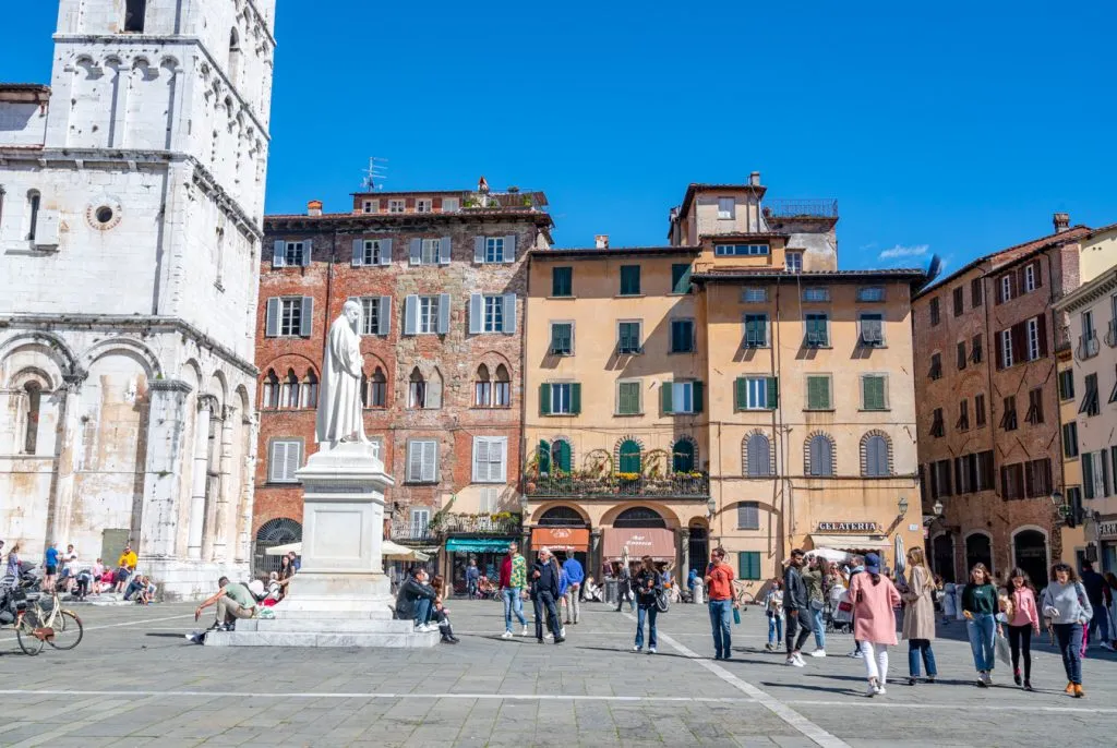 bustling piazza next to basilica on a sunny day in lucca tuscany