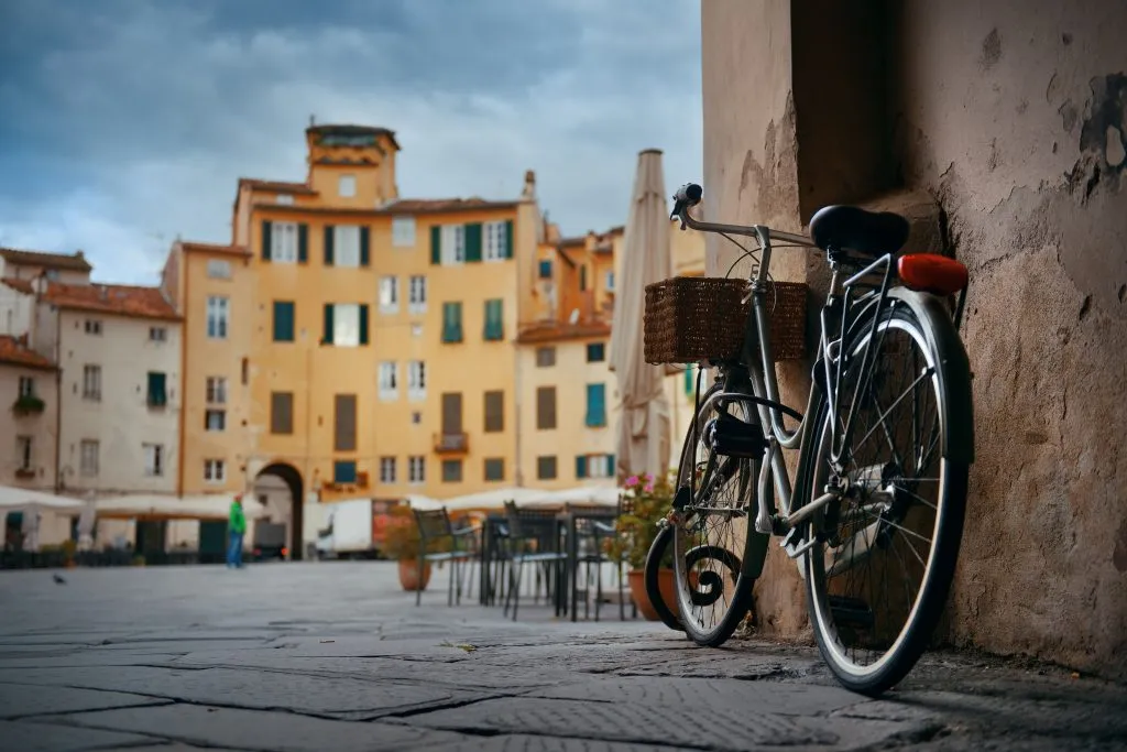black bike parked at the entrance to piazza dell'anfiteatro, one of the best activities in lucca italy