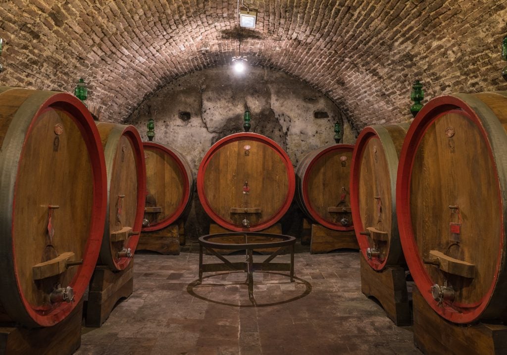 wine barrels aging in a cellar in montepulciano italy