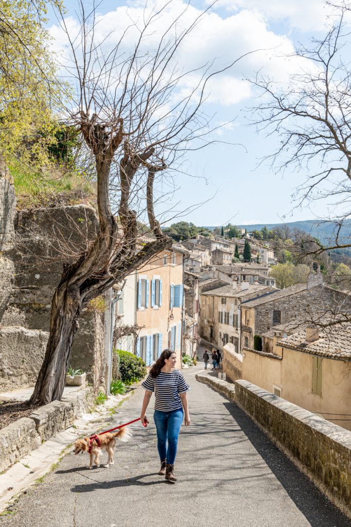 kate storm and ranger storm walking up a hill through the beautiful village of menerbes, one of the best south of france places to visit