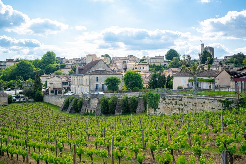 view of vineyards with buildings in st emilion behind them