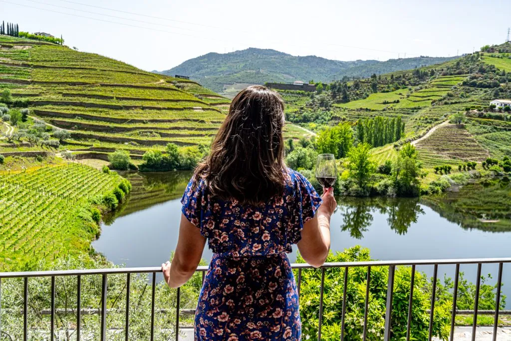 kate storm holding up a glass of port in the douro valley portugal