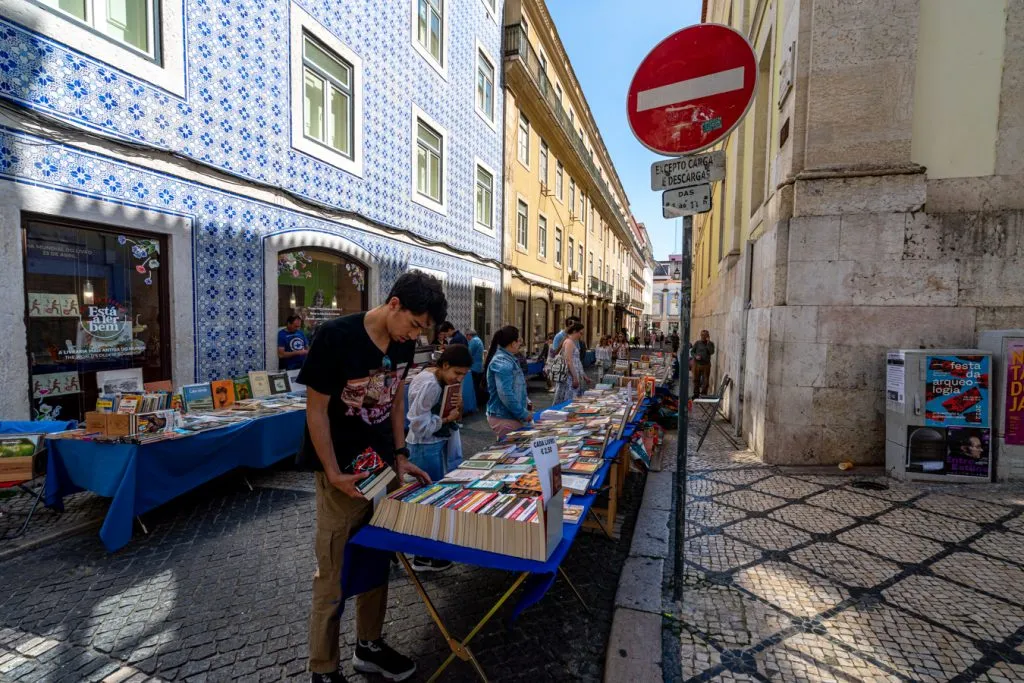 people shopping for books outside of livraria bertrand in lisbon, looking for souvenirs from portugal to buy