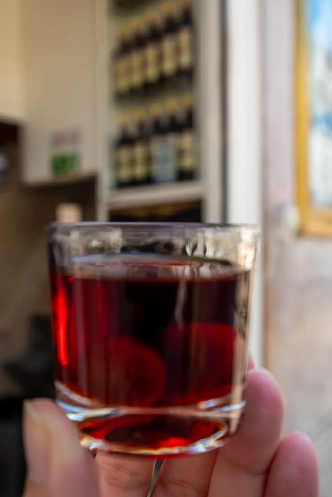 glass of ginjinha being held up at a ginjinha in lisbon portugal