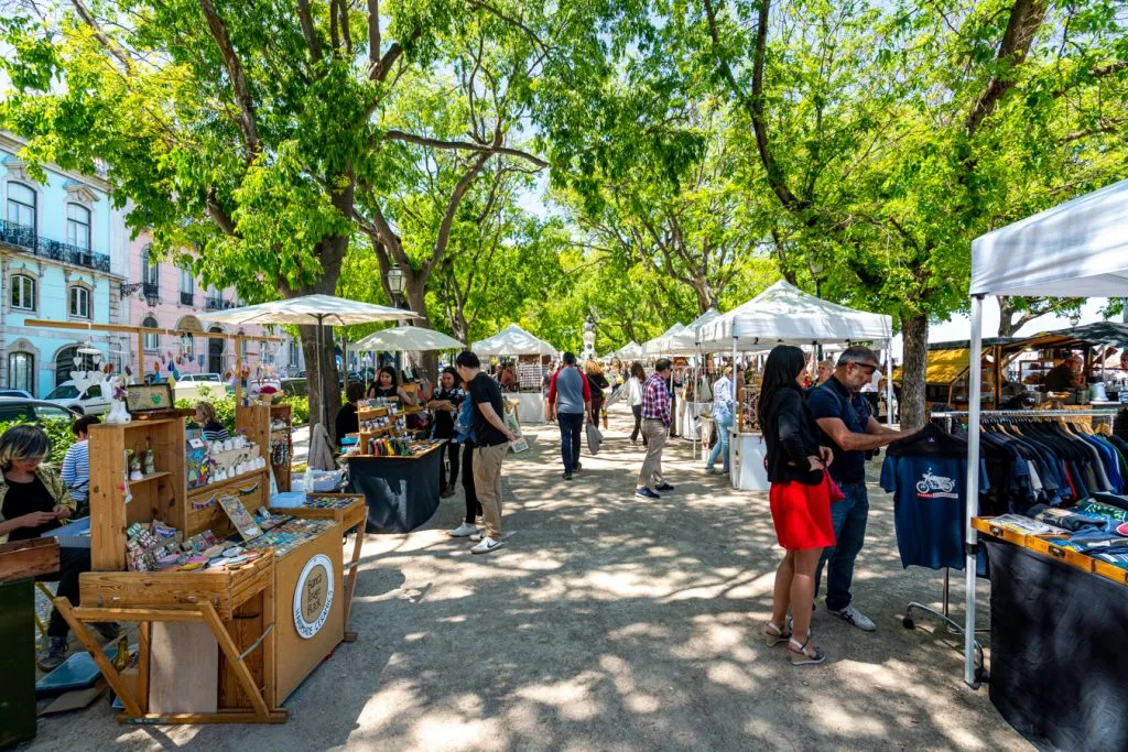 people shopping at a shady market in lisbon portugal