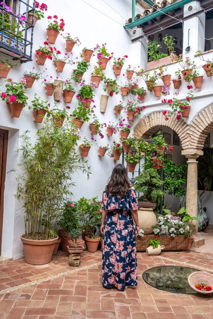 kate storm in a floral dress visiting one of the patios of cordoba during a spain vacation