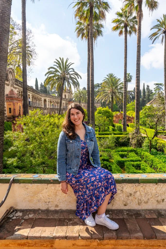 kate storm in a blue dress overlooking the alcazar gardens in seville spain