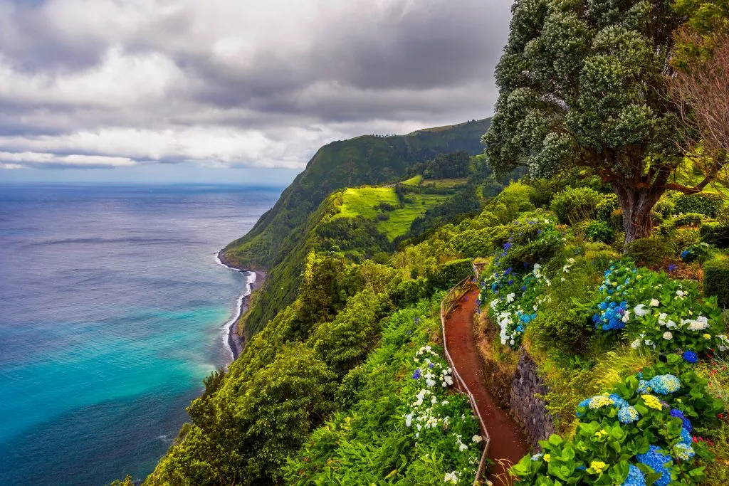 hiking trail along a lush coast on azores road trip portugal