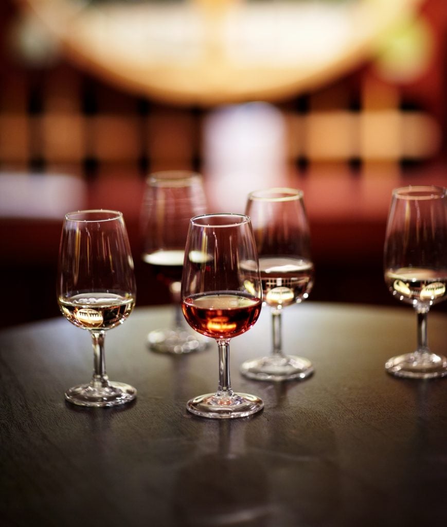 several glasses on port on a table during a port tasting in porto vs lisbon portugal