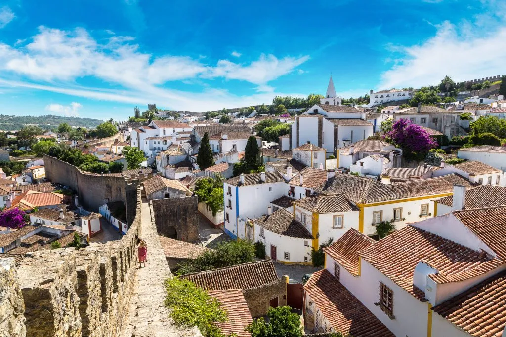 view of obidos portugal from castle ramparts, one of the best stops on a portugal road trip itinerary