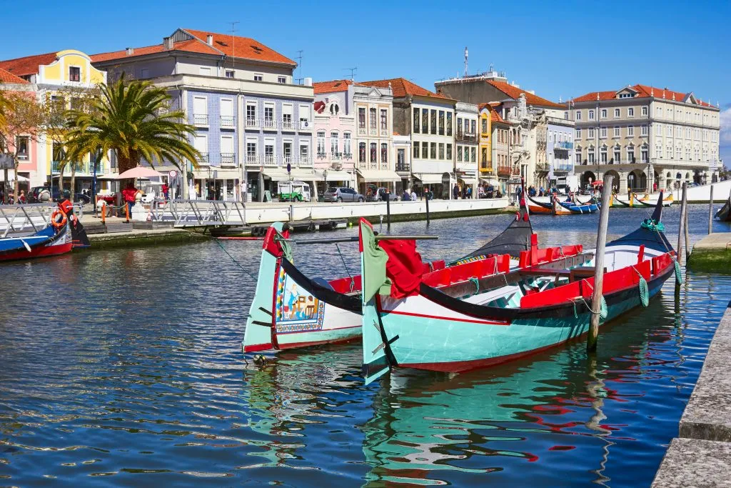 colorful boats in a canal in aveiro portugal with buildings in the background