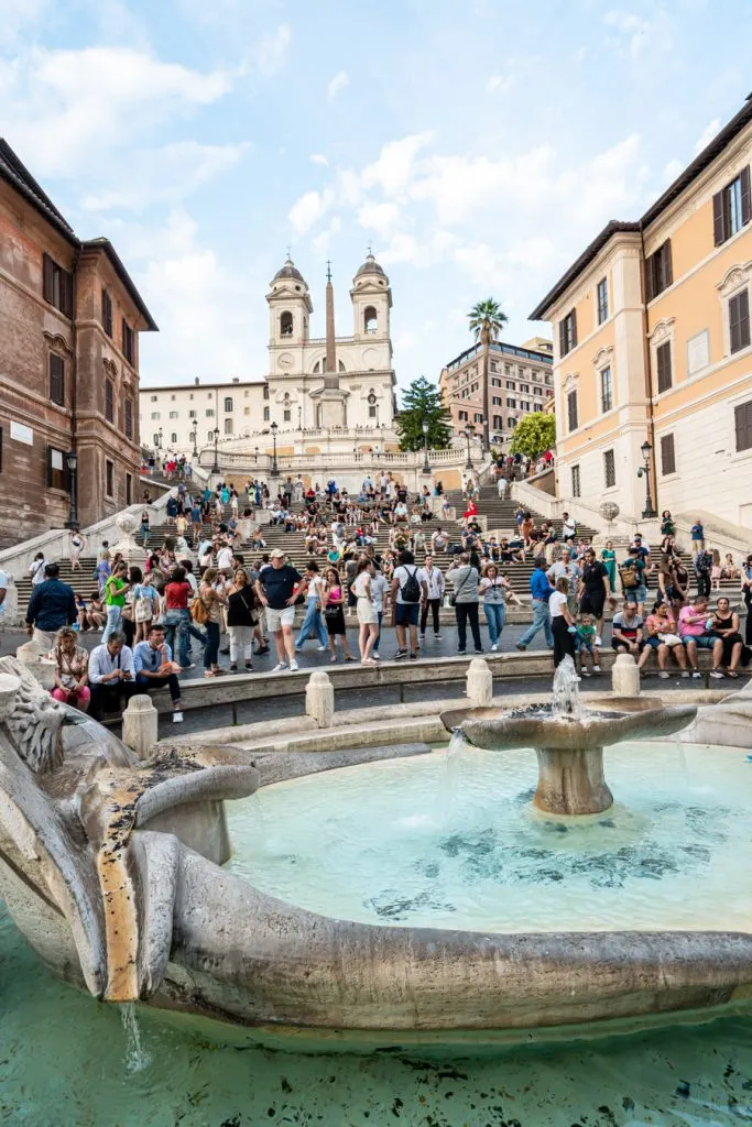 vertical photo of the spanish steps rome with fountain in the foreground, part of a one day rome itinerary
