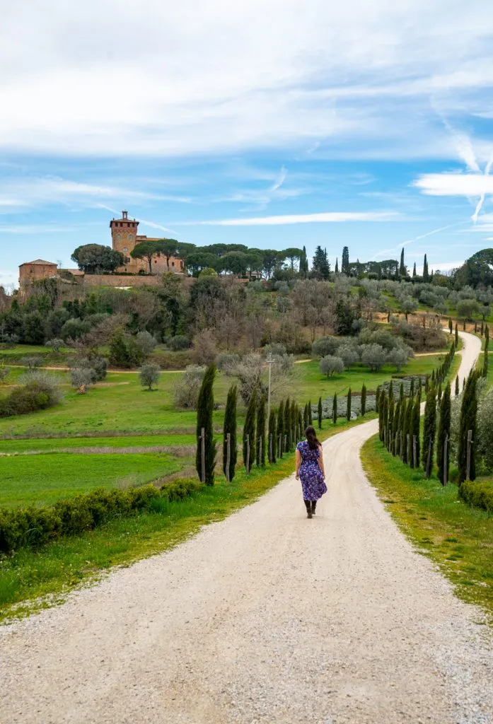 kate storm walking down a dirt road in tuscan countryside