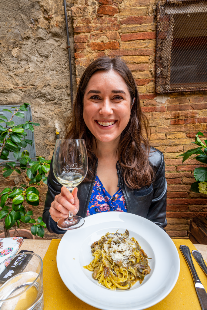 kate storm with pasta and wine at a restaurant pienza tuscany