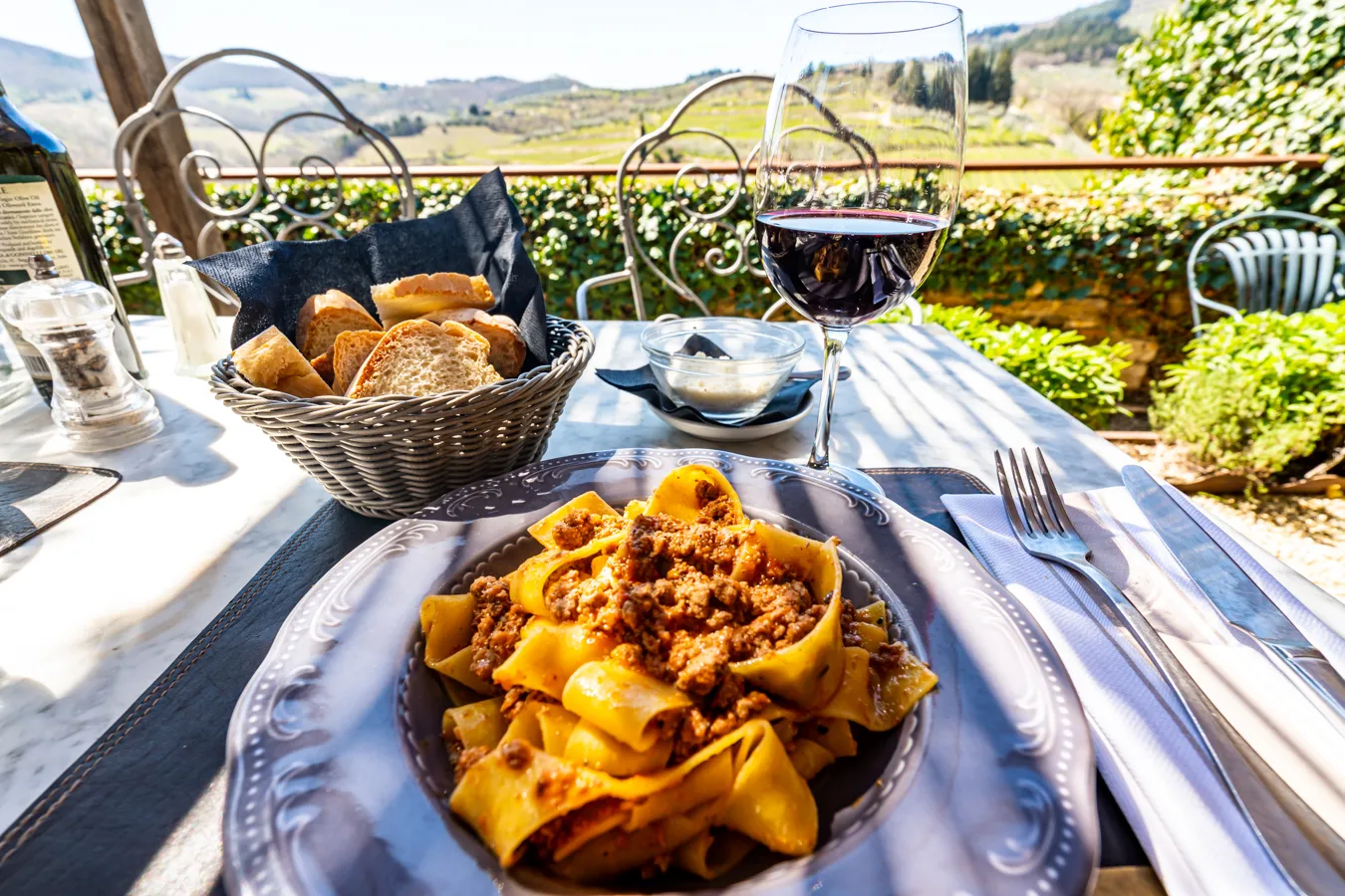 pappardelle al ragu with red wine at an outdoor table when eating in italy restaurant