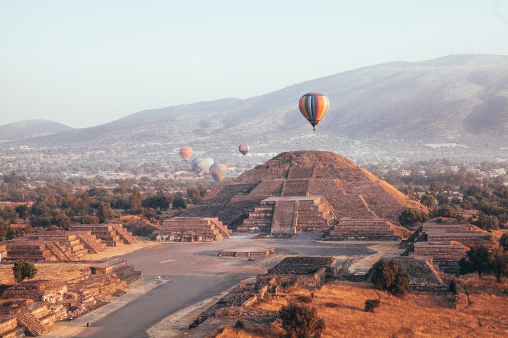 hot air balloons rising over teotihuacan in the early morning