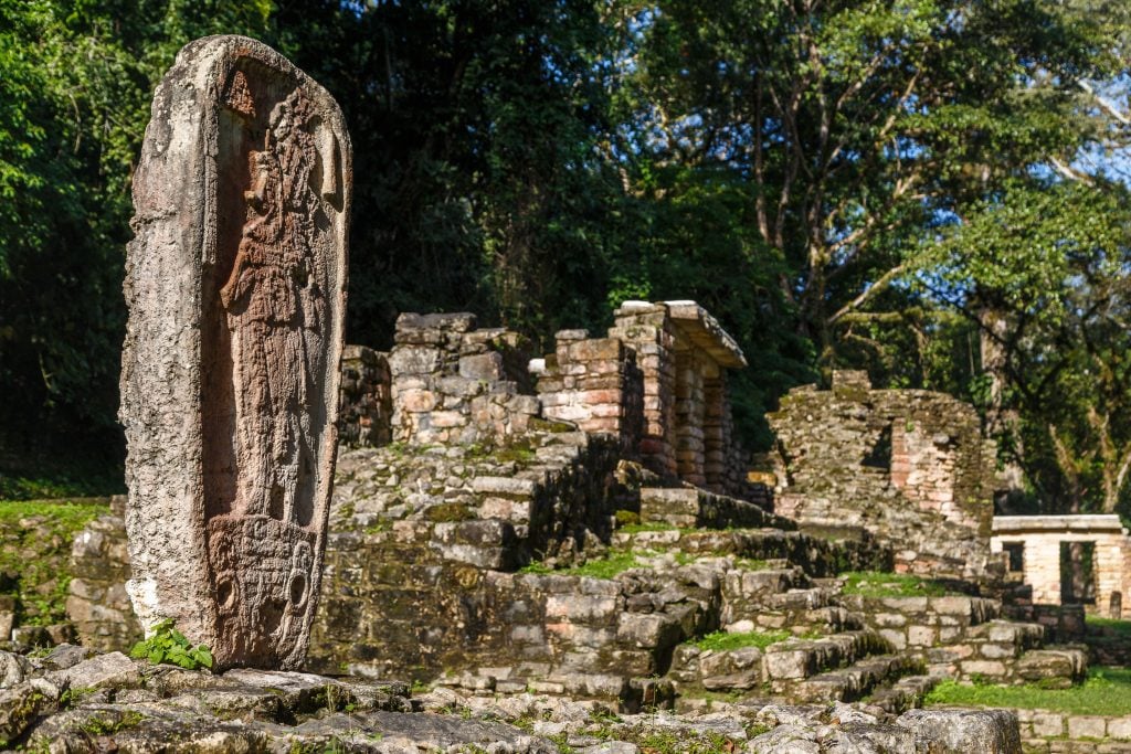 Yaxchilan mexico ruins with a statue on the left side