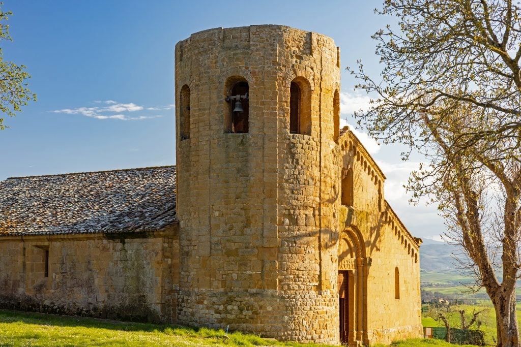 Pieve di Corsignano with round stone tower, one of the best things to do in pienza