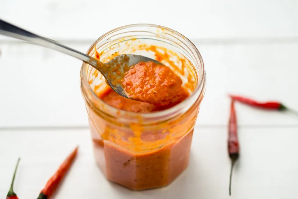 jar of peri peri sauce with a spoon in it, an excellent portuguese souvenir
