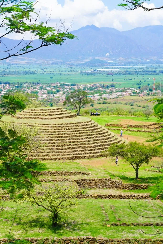 round Guachimontones pyramid covered in grass as seen from afar, one of the most unique mexico ruins to visit