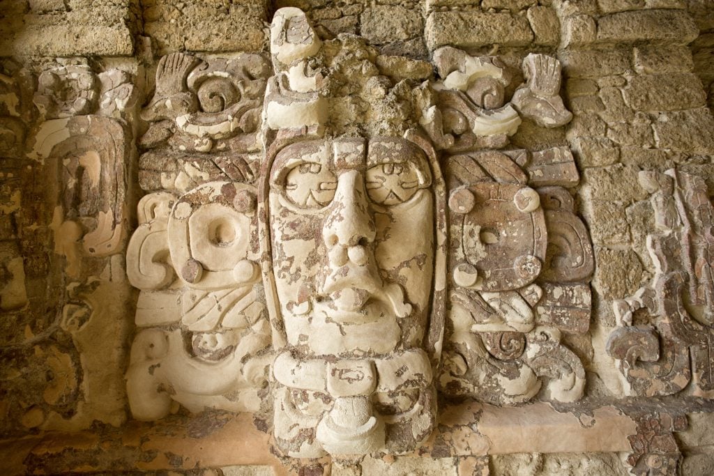 well preserved statue carved into a pyramid in kohunlich