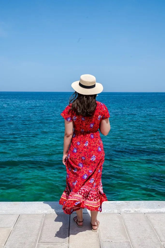 kate storm in a red dress overlooking the adriatic sea during an itinerary for puglia vacation