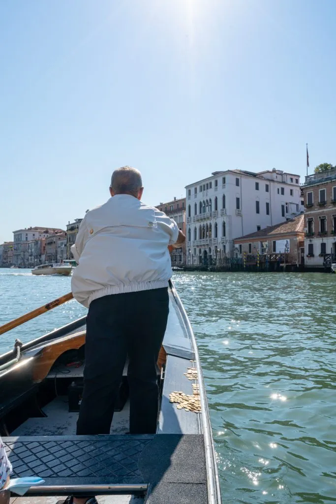 gondolier in venice piloting a gondola traghetto across the grand canal