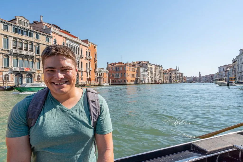 jeremy storm riding on the edge of a traghetto gondola venice italy grand canal