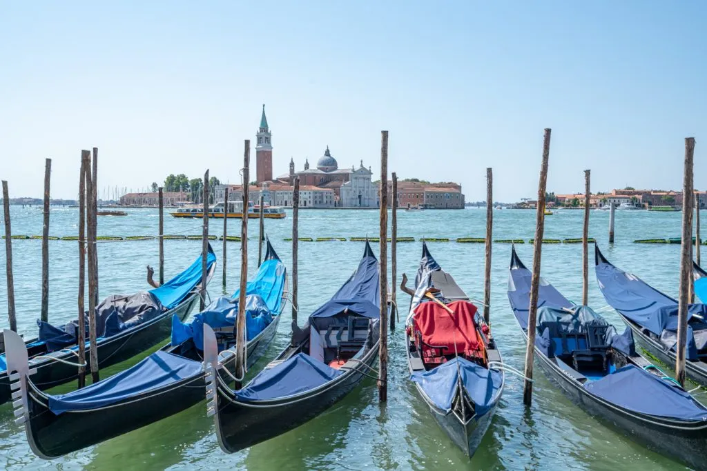 gondolas parked on the lagoon with san giorgio maggiore in the background during summer venice italy