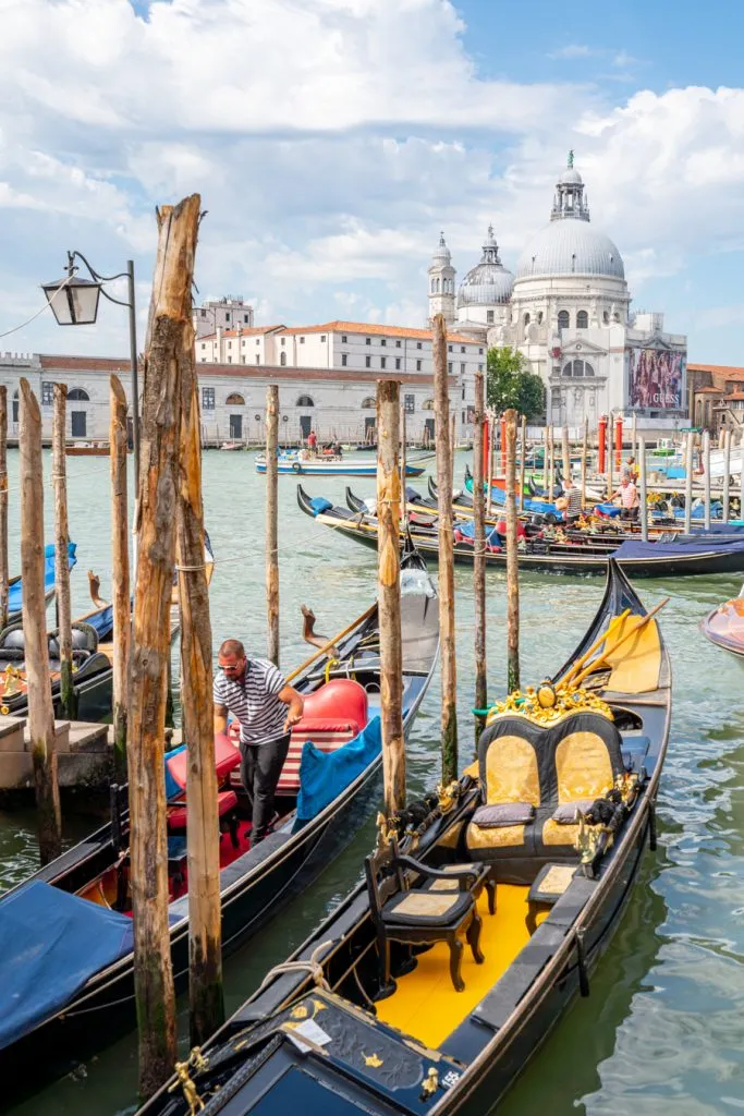 gondolas parked near st marks square with basilica in the background