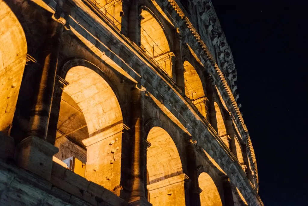windows of the colosseum lit up at night